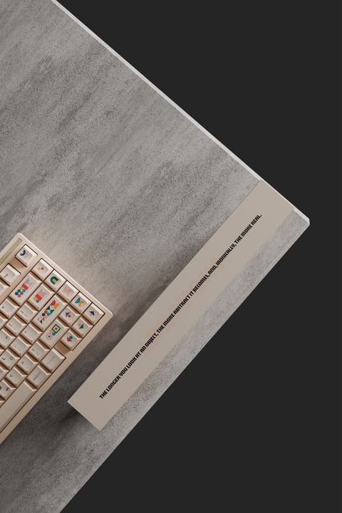 Looking down on the corner of a concrete plinth: the keyboard and the box's side panel, printed with a line about abstraction