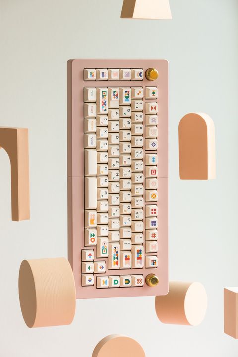 Close-up of the full board, its cream keys covered in colourful shape novelties, between two brass knobs