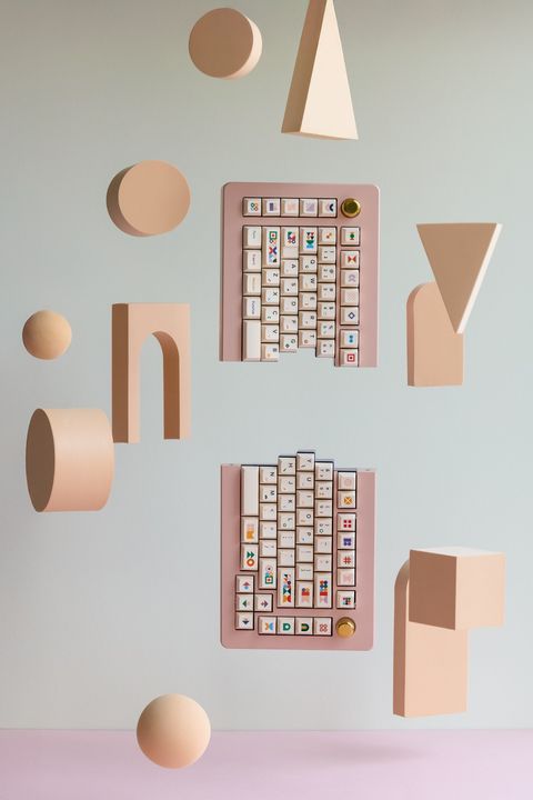 The two halves of the split keyboard floating apart, one above the other, among the peach shapes