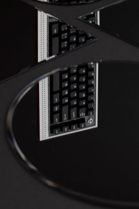 Abstract mirrored reflection shot of a black keyboard with Japanese-language keycaps