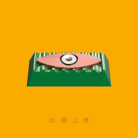 The Motif Enter Artisan from the front, its green ribbed body and pink eye on an orange background