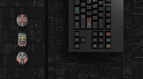 3D-rendered Tribal mask keycaps beside a rendered keyboard on a dark tribal-pattern surface