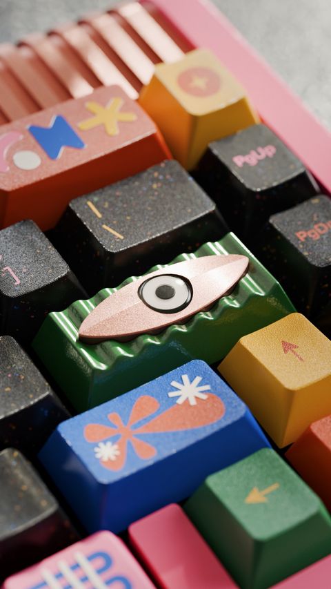 The artisan from a low angle, framed by a coral flower keycap and a yellow arrow key